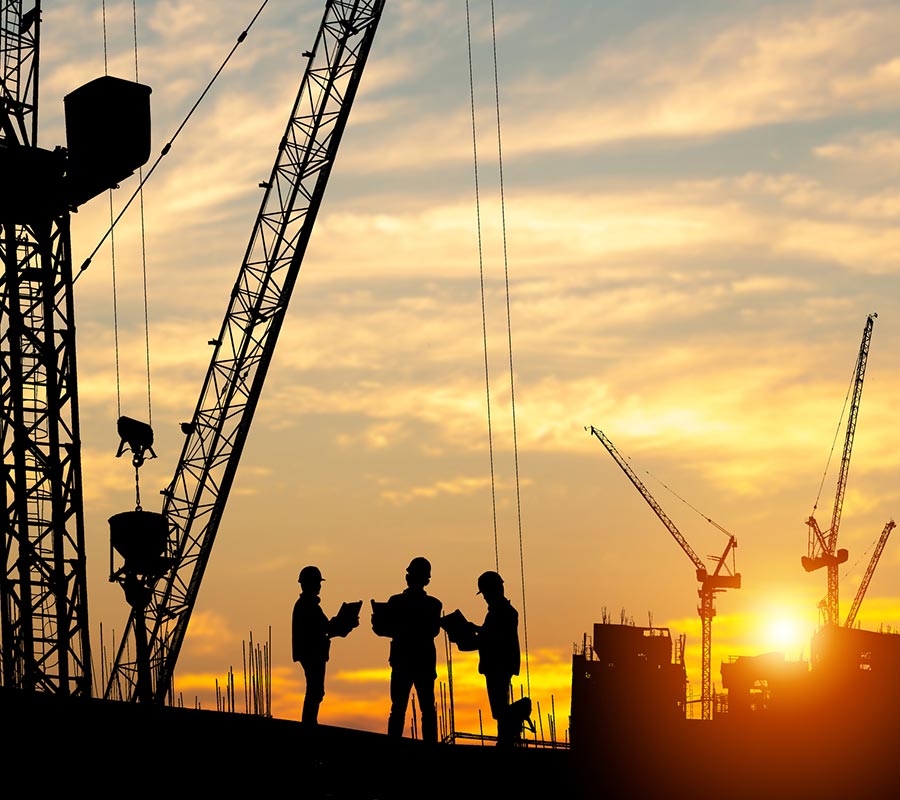 fire-stopping Group of 3 men on construction site at sunset